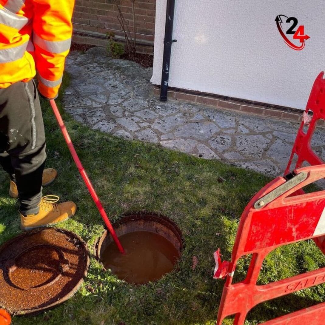 Engineer jetting a blocked drain through an open chamber